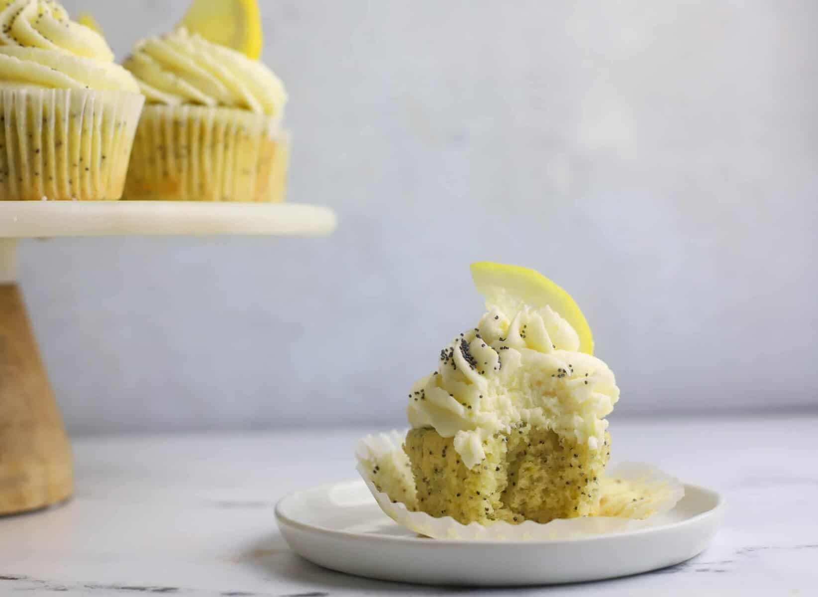 lemon buttercream frosting topped lemon cupcake on a plate