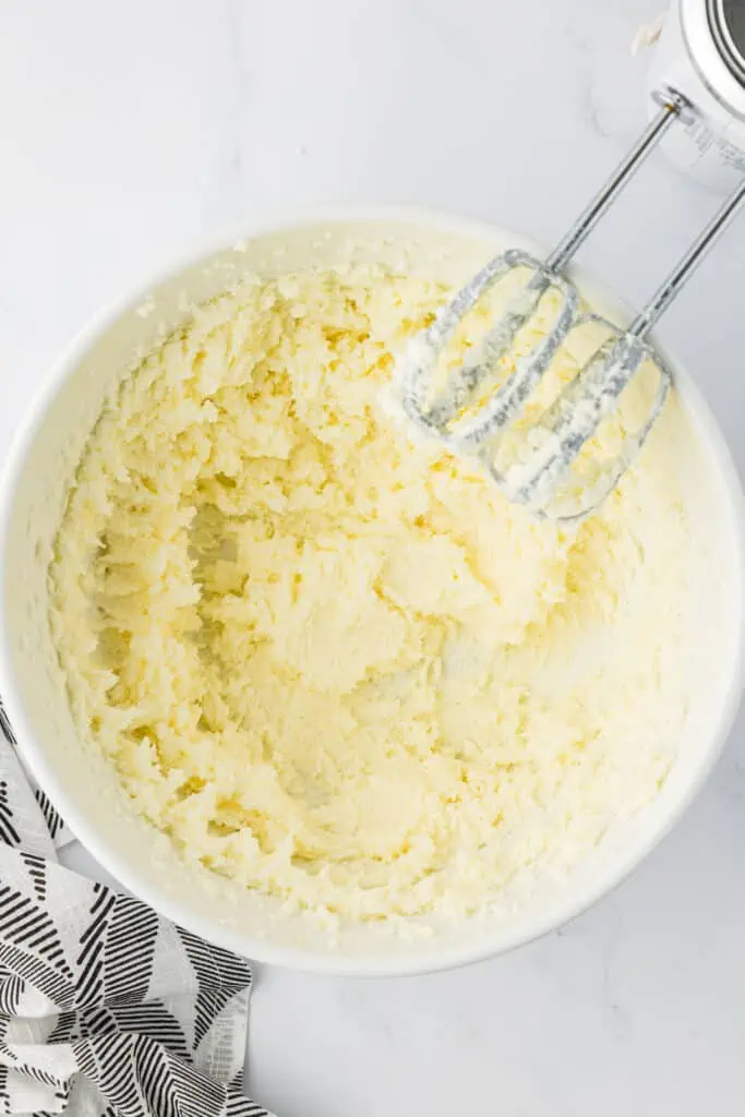 butter and sugar creamed together in a bowl with a mixer