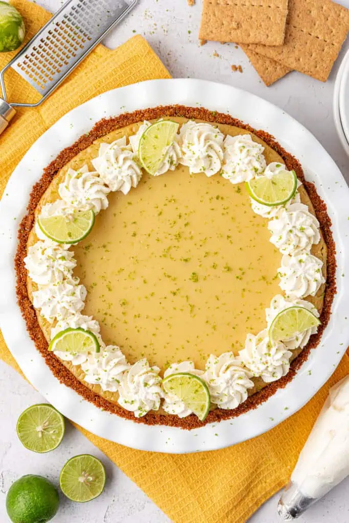 whole key lime pie topped with whipped cream and key lime slices