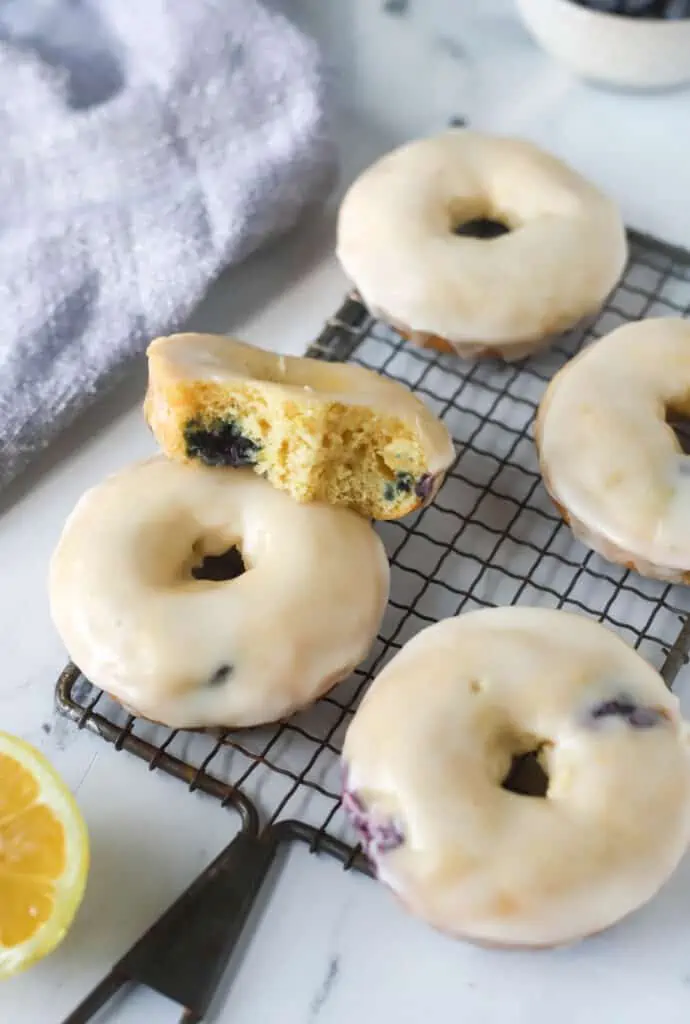 baked lemon blueberry donuts on a cooling rack