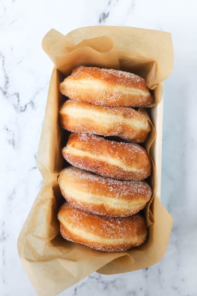 five sugar donuts sitting in a loaf pan