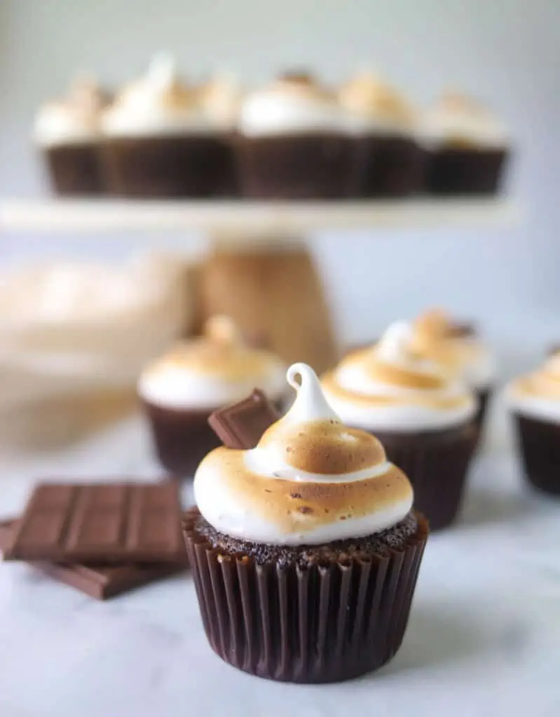 S'mores cupcake with more cupcakes in the background on a cake stand