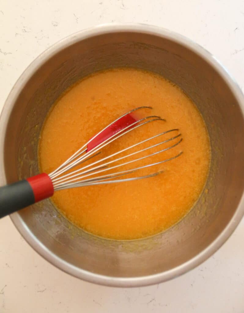 wet ingredients for pumpkin bread in a bowl with a whisk