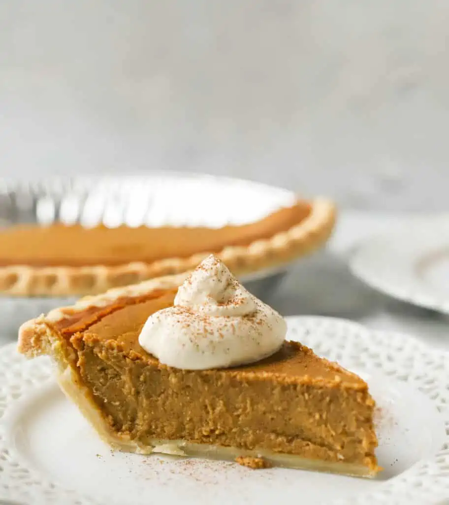 slice of pumpkin pie on a plate with whipped cream