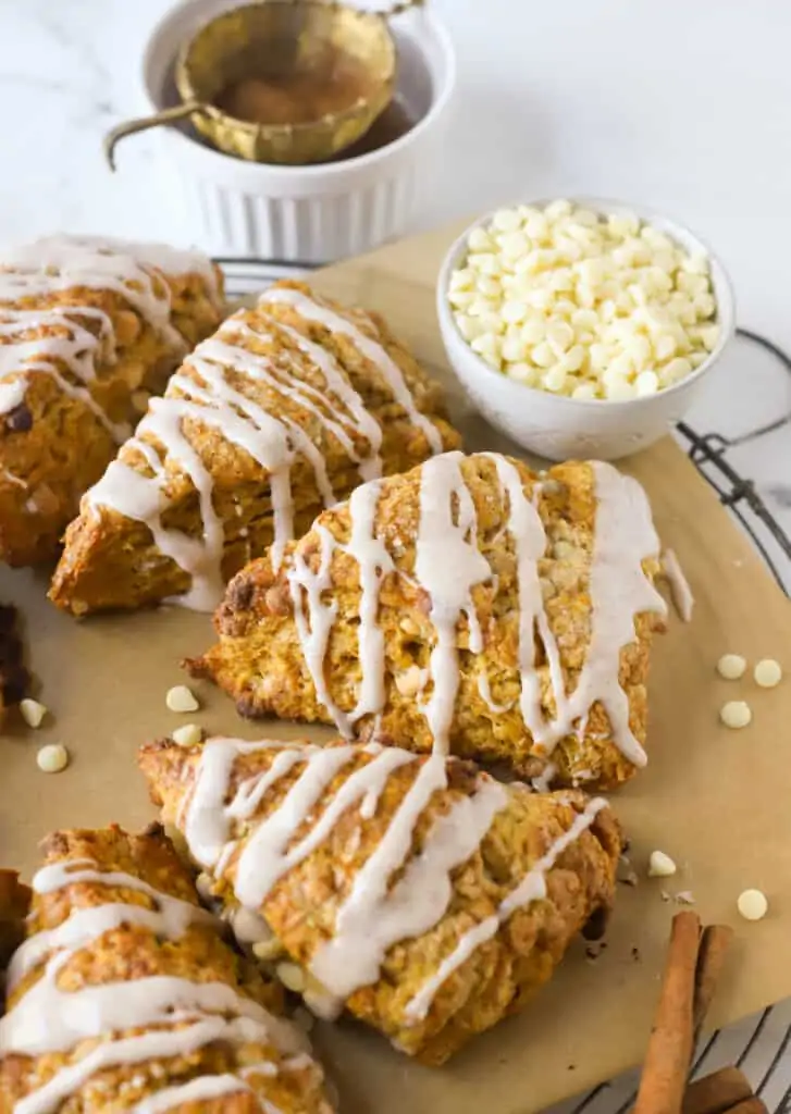 pumpkin scones on parchment and a dish of white chocolate chips