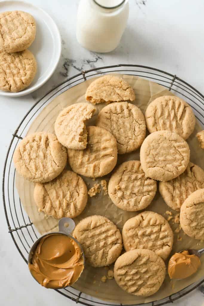 peanut butter cookies on a rack and white plate and glass of milk