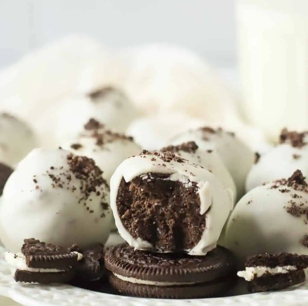 white chocolate covered oreo balls on a white plate