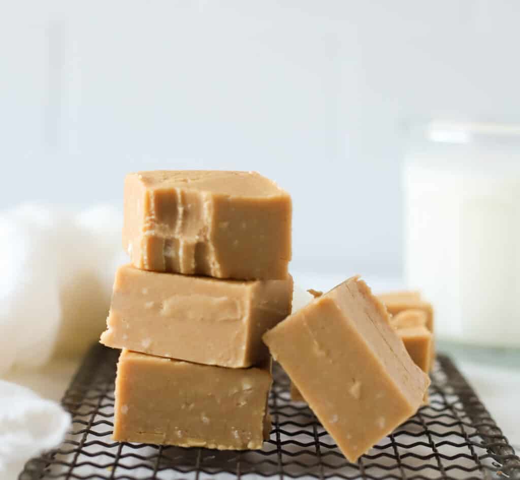 four squares of peanut butter fudge, stacked, one has a bite taken out of it