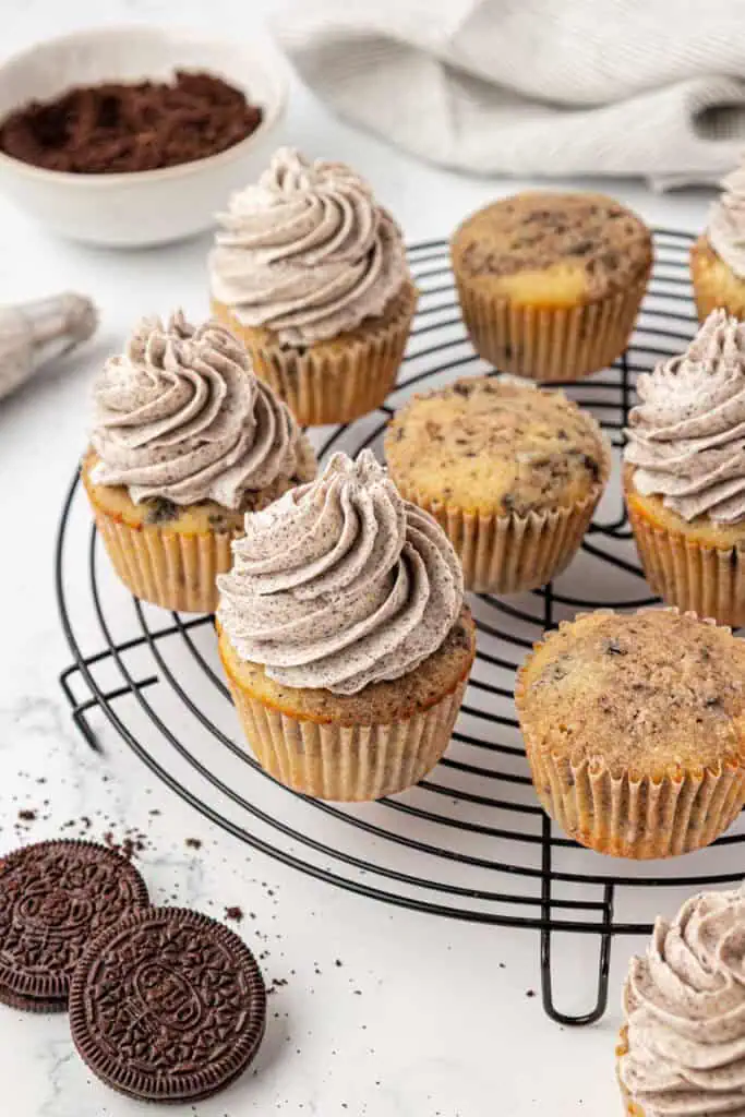 oreo cupcakes on a wire rack, some frosted, some plain