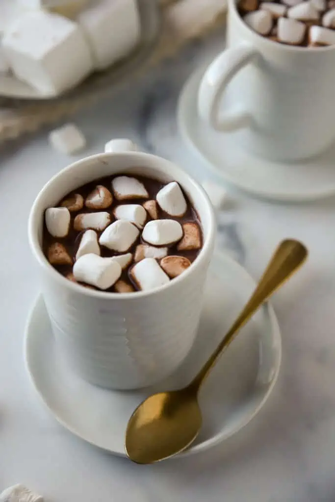 cup of hot cocoa in a white mug topped with marshmallows