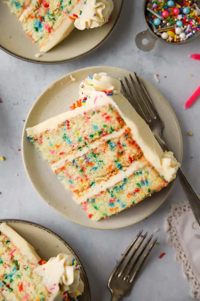 slice of homemade funfetti cake on a plate with a fork