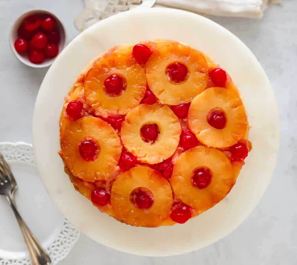 top down view of a whole pineapple upside down cake on a cake platter
