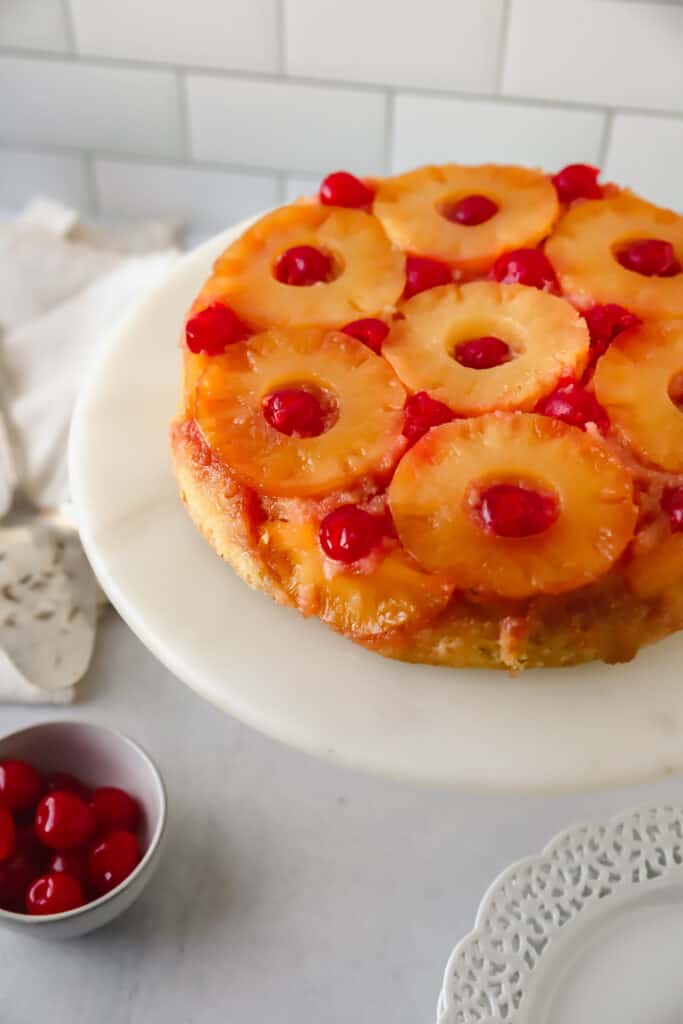 whole pineapple upside down cake on a white cake stand