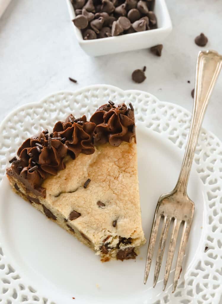 slice of chocolate chip cookie cake on a white plate with a fork