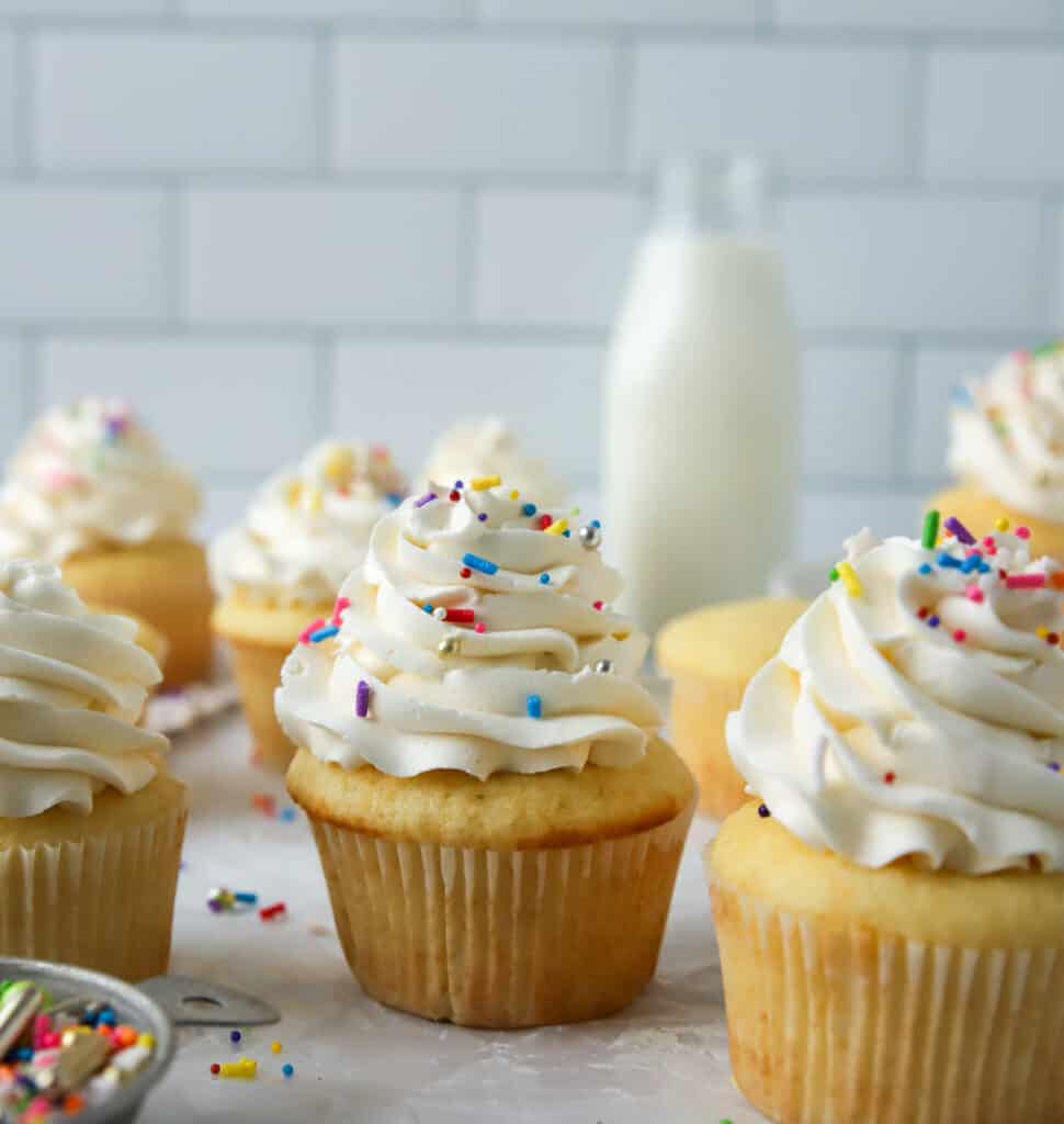 vanilla cupcakes with vanilla frosting and sprinkles