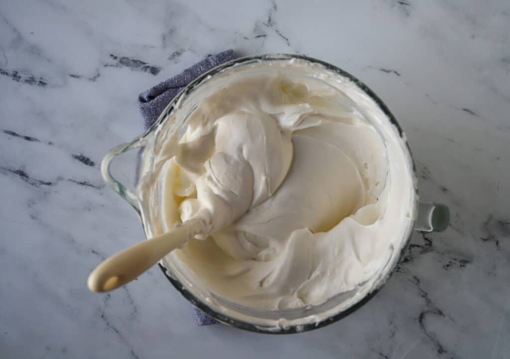 spatula in a bowl folding in flour into whipped egg white mixture