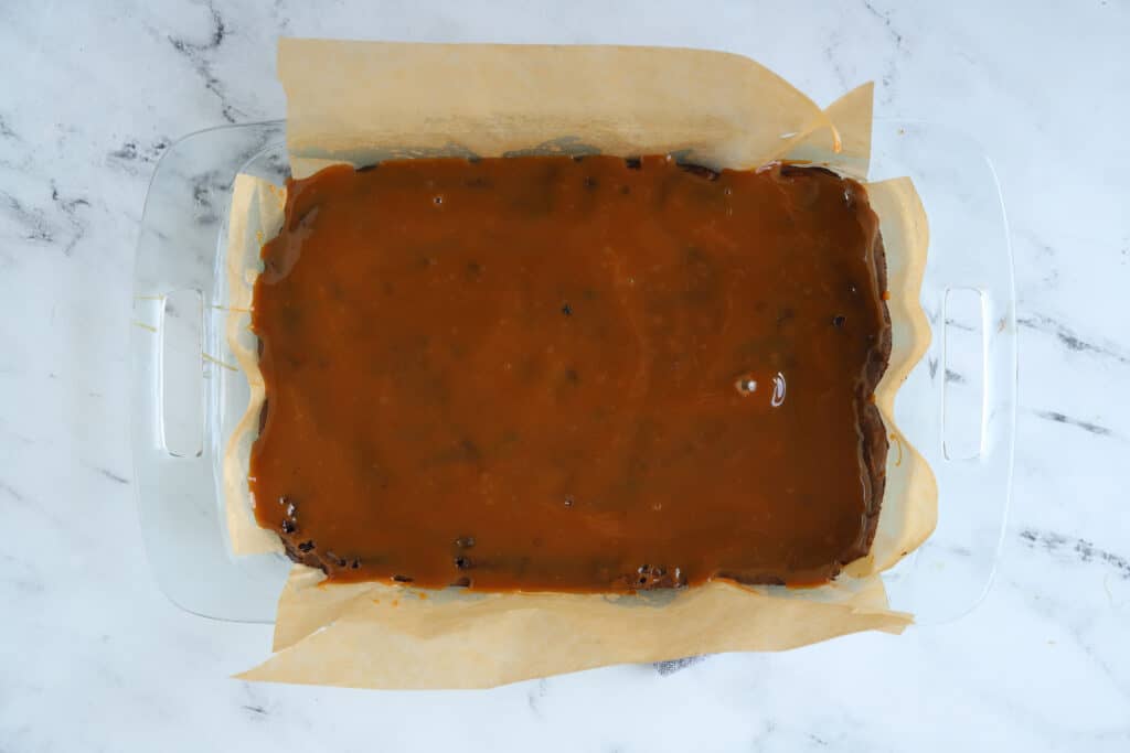 baked caramel turtle brownies with caramel sauce spread on top