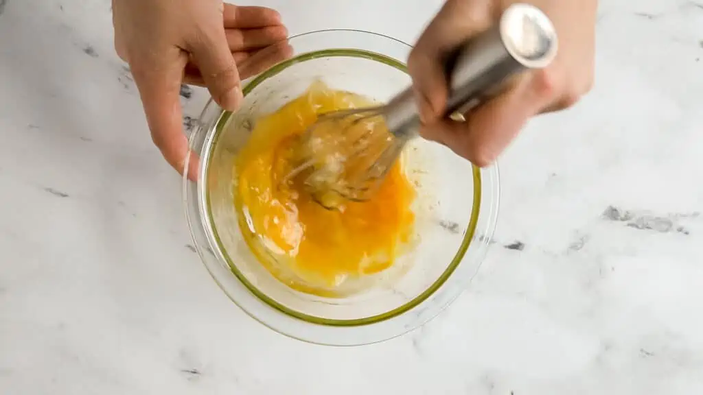 hand whisking zucchini muffin wet ingredients