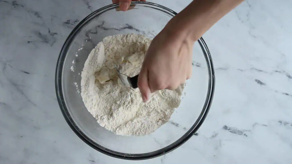 hand using a pastry blender and cutting in the butter into the flour