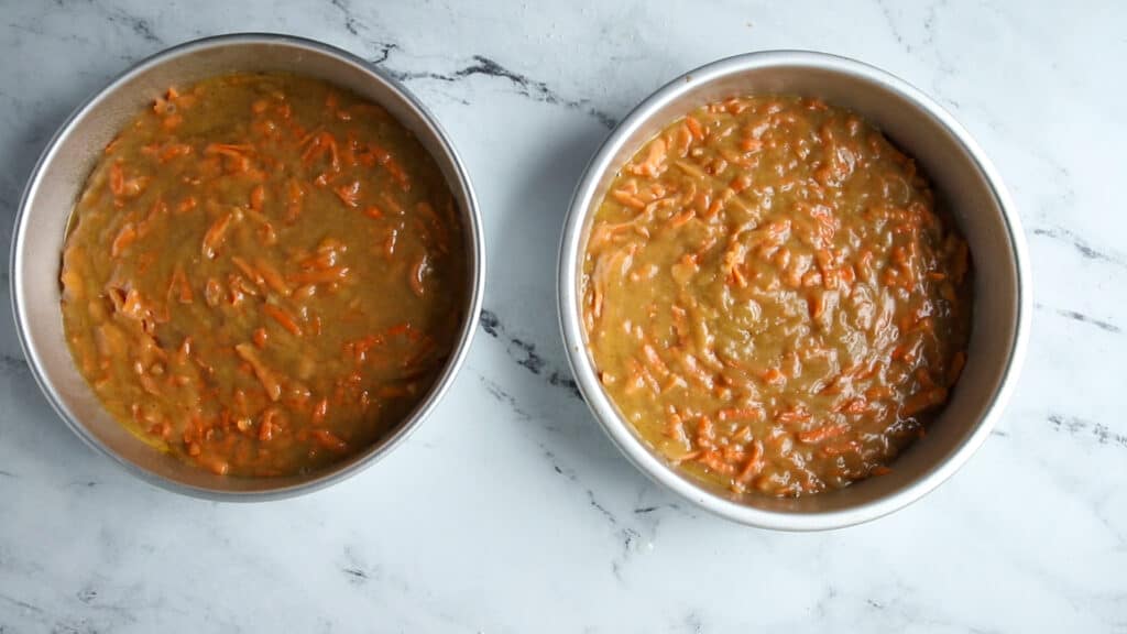 two cake pans filled with carrot cake batter