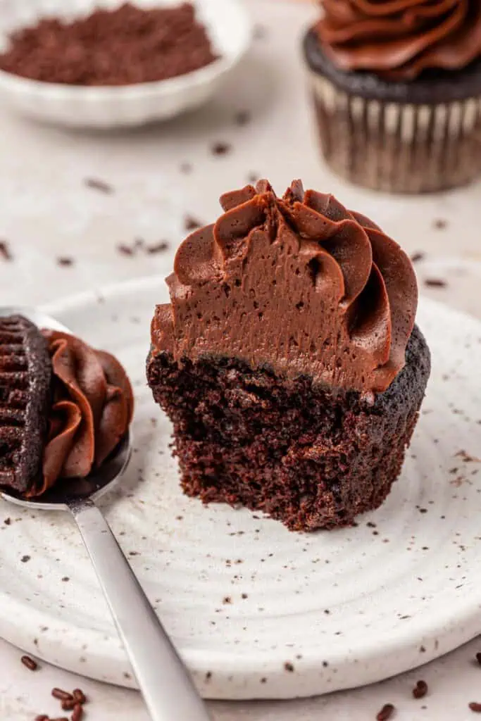 chocolate cupcake on a plate with a forkful missing