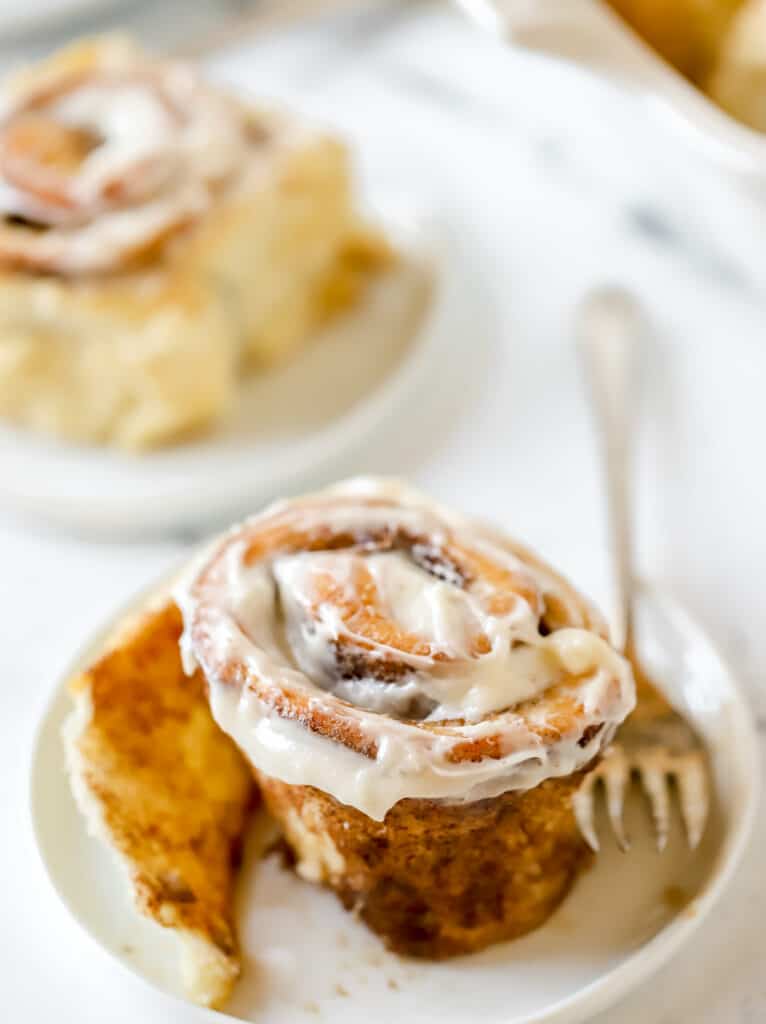 cinnamon roll on a plate with a fork