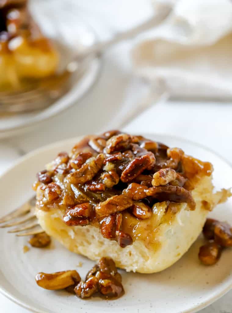 pecan sticky bun on a plate with a fork