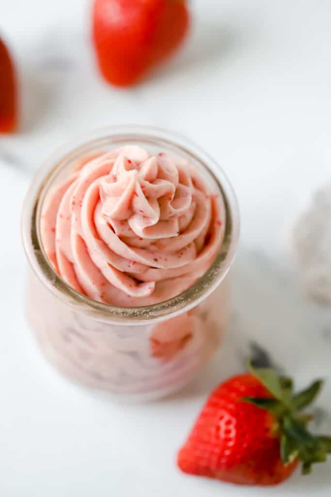 strawberry cream cheese frosting piped into a glass jar