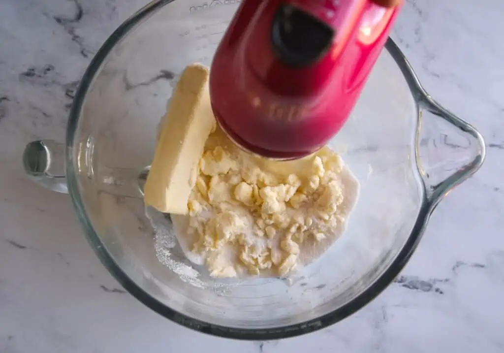 butter and sugar being creamed together with a pink hand mixer