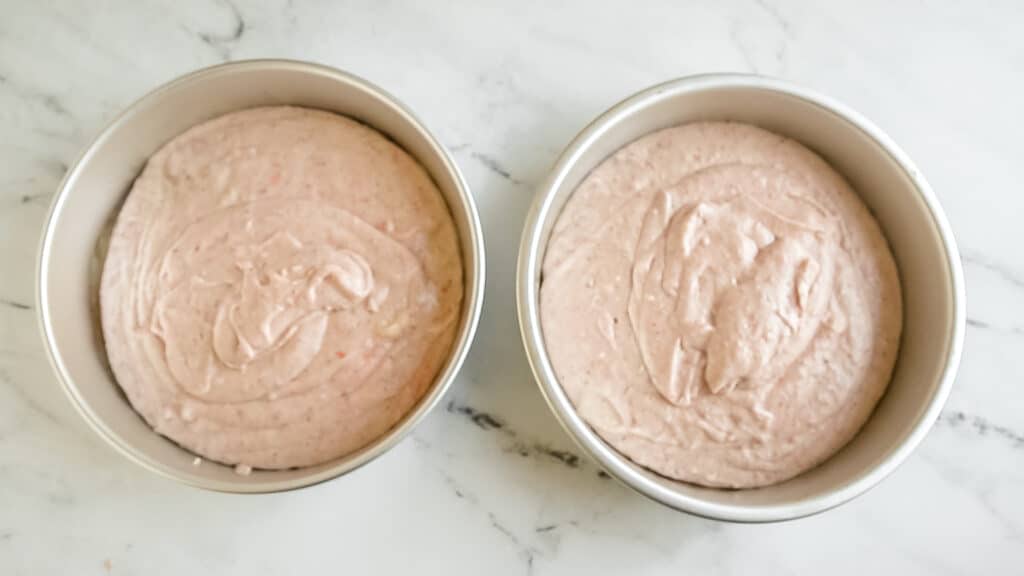 two unbaked strawberry cakes in pans