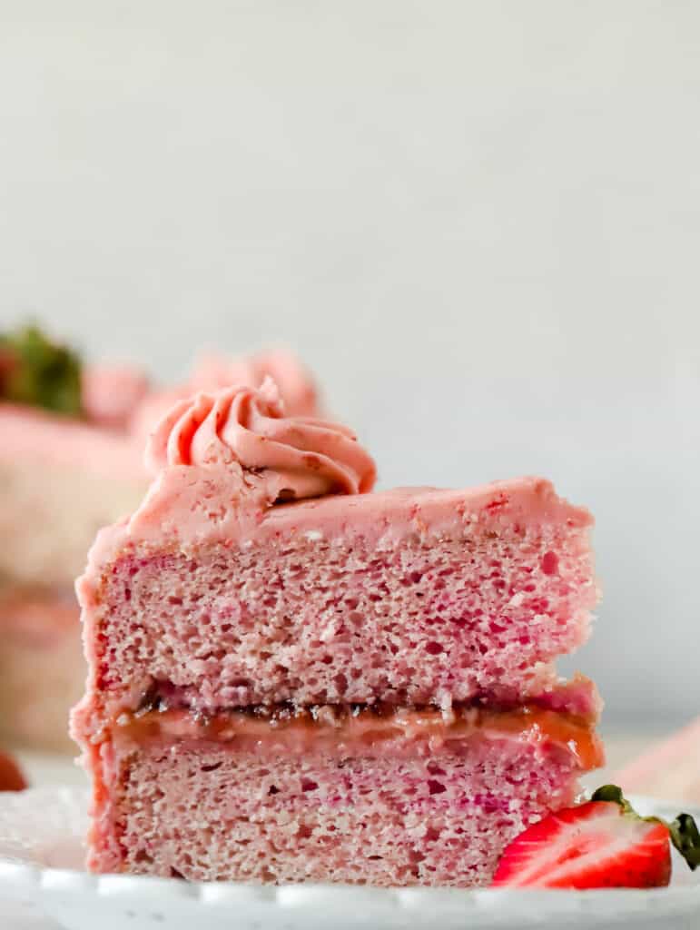 slice of strawberry layer cake upright on a plate