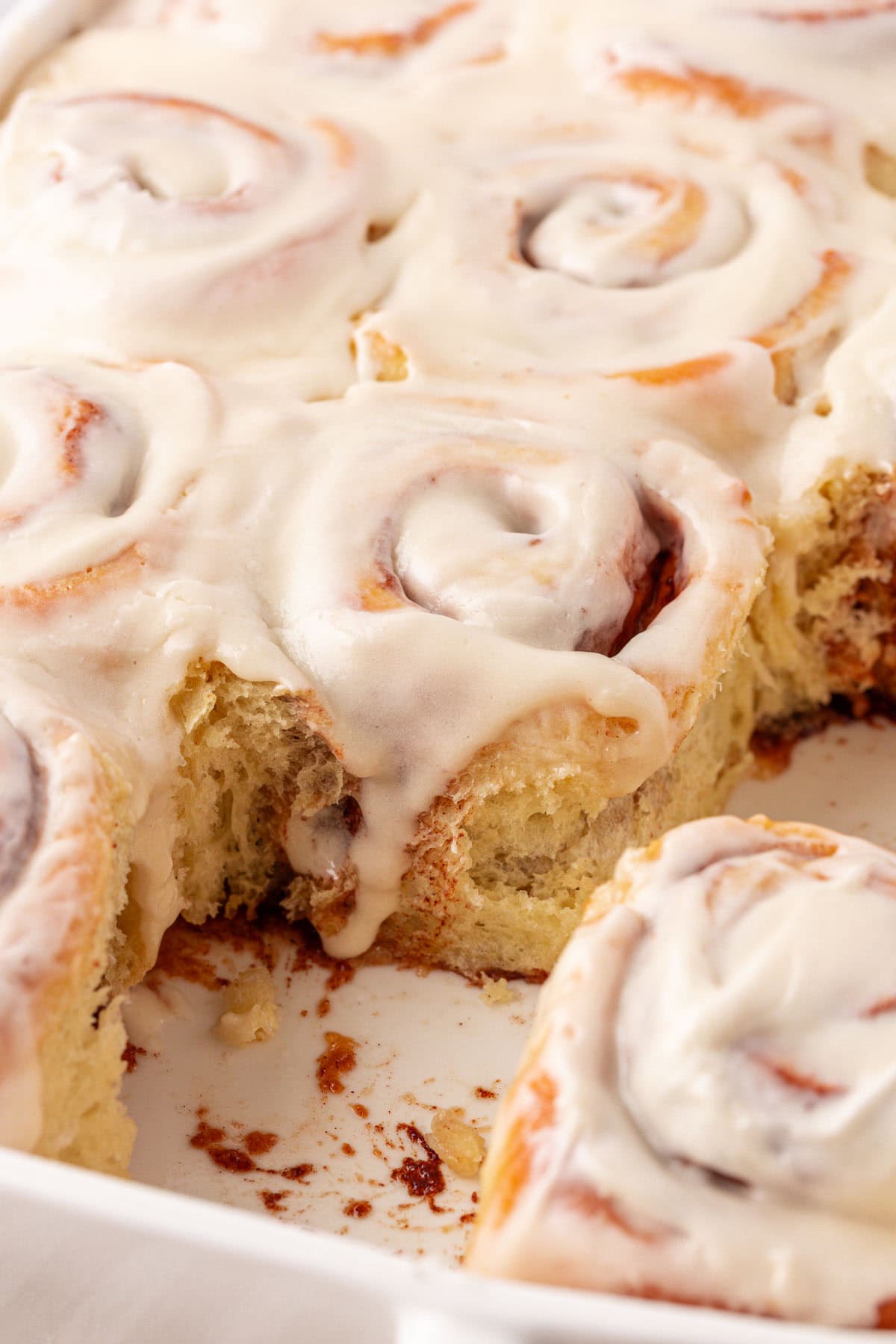 pan of cinnamon rolls with a few cinnamon rolls missing