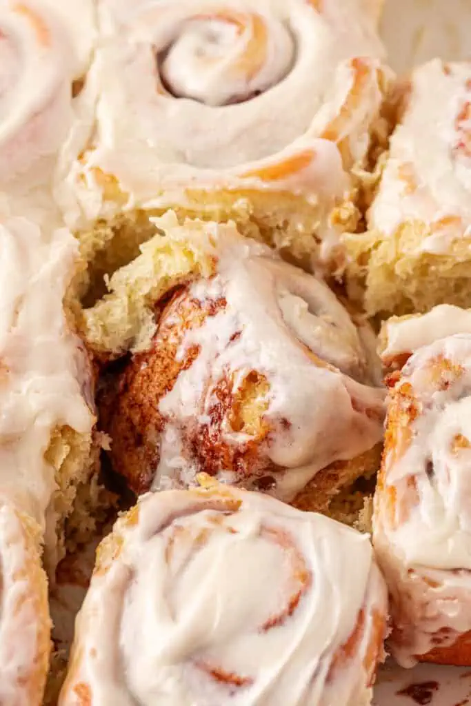 pan of cinnamon rolls with a cinnamon roll turned on its side