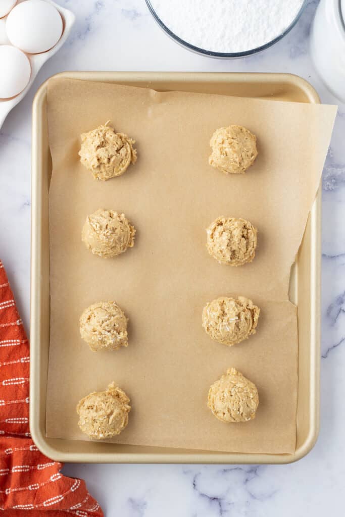 unbaked oatmeal cookies scooped onto baking sheet