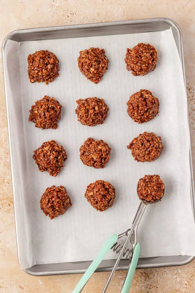 no bake cookies on a cookie sheet with a cookie scoop
