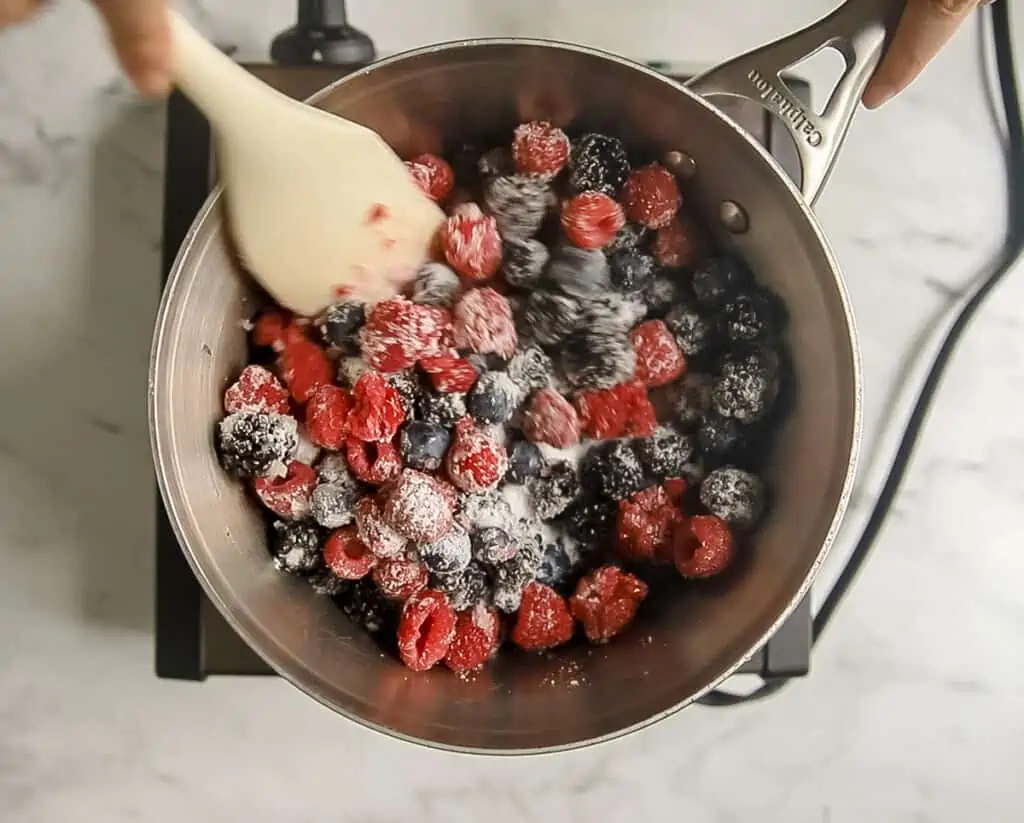 triple berry pie filling in pot on stovetop with white spatula