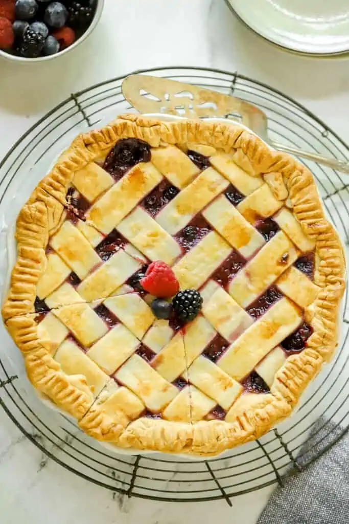 whole triple berry pie on a cooling rack