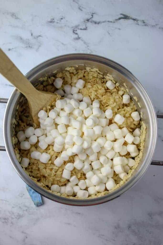 large pot with wooden spoon, rice krispies and mini marshmallows in it