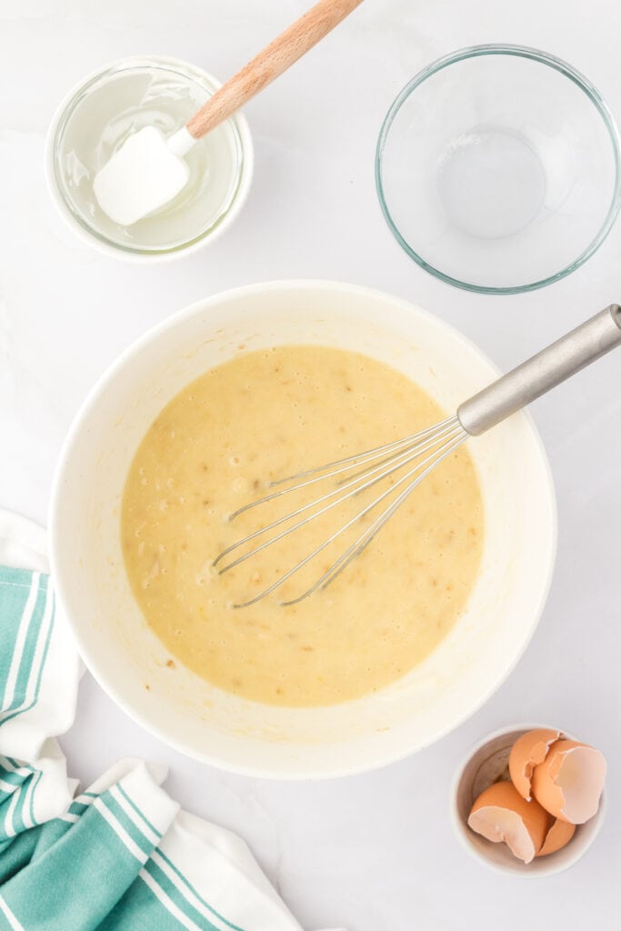 banana bread wet mixture in a bowl with a whisk