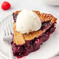 slice of berry pie topped with ice cream