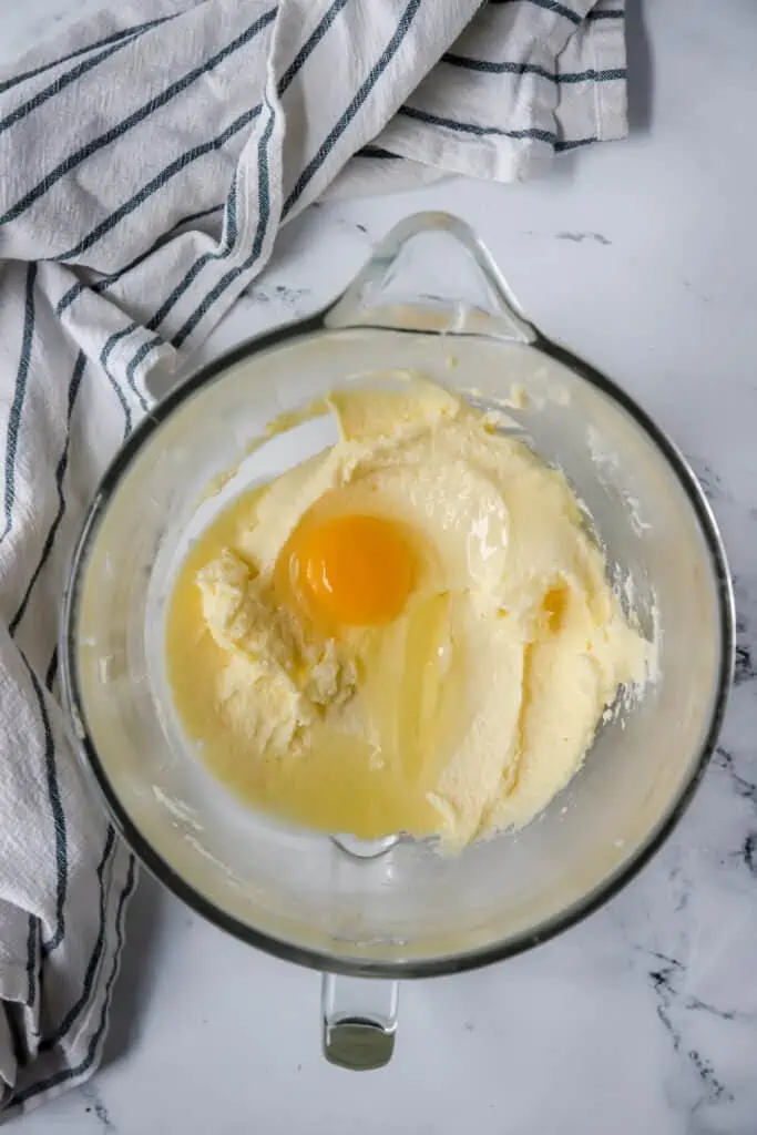 creamed butter and sugar in bowl with egg on top