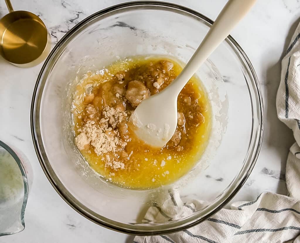 melted butter and sugars in bowl with white spatula