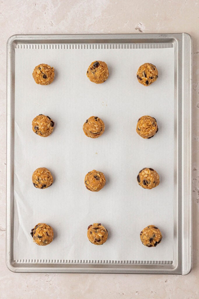 twelve cookie dough balls on a ccookie sheet