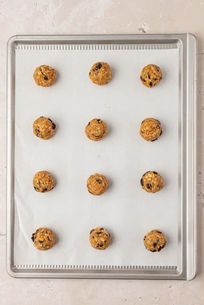 twelve cookie dough balls on a ccookie sheet