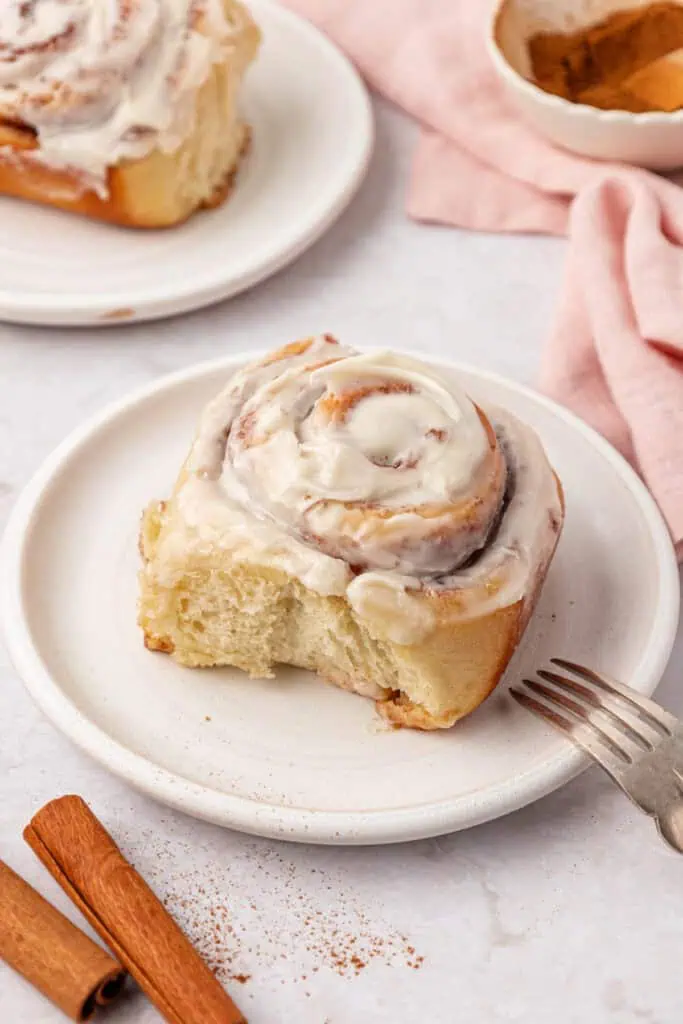 cinnamon roll on a plate with a fork