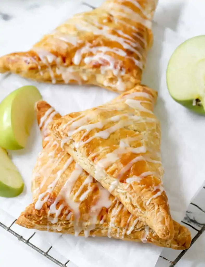 three apple turnovers on a wire rack