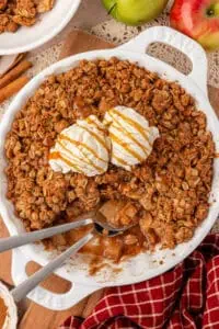 dish of apple crisp topped with ice cream and a spoon