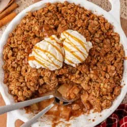 dish of apple crisp topped with ice cream and a spoon