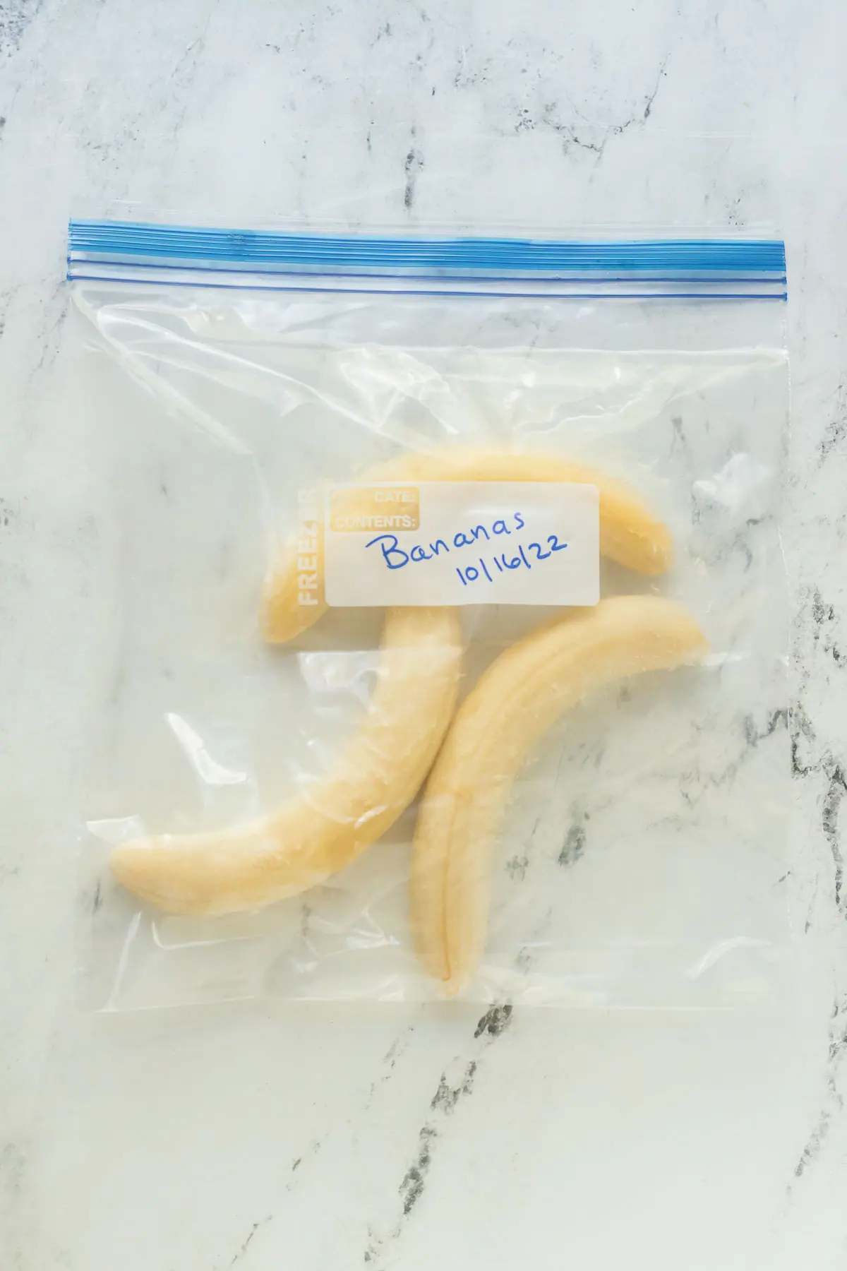 freezer bag with three frozen bananas in it