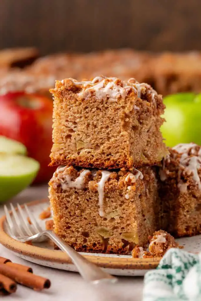 two slice of apple crumb cake on a plate stacked on top of each other